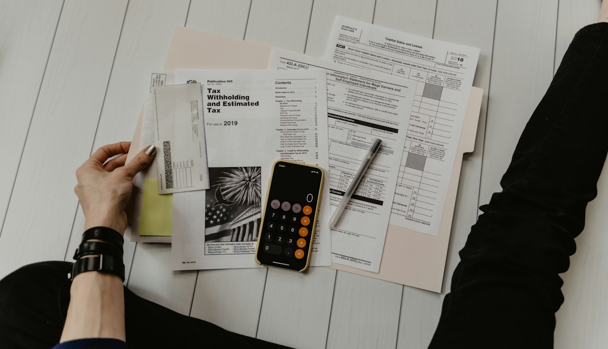 Person with a calculator reviewing financial documents